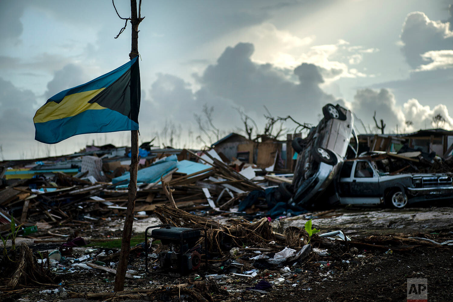 A Bahamas flag flies tied to a sapling, amidst the rubble left by Hurricane Dorian in Abaco, Bahamas, Monday, Sept. 16, 2019. (AP Photo/Ramon Espinosa)