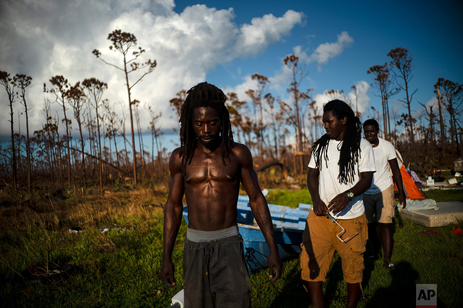 Dexter Edwards, front, his brother Nathanael Edwards right, and his cousin Valentino Ingraham walk amid one of their family's homes destroyed by Hurricane Dorian in Rocky Creek East End, Grand Bahama, Bahamas, Sunday, Sept. 8, 2019. “Right now, ain’t much joy. You just gotta try to keep your head up,” Edwards said. “There’s always a future. Only thing we can do right now is rebuild, rebuild and try to move forward.” (AP Photo/Ramon Espinosa)