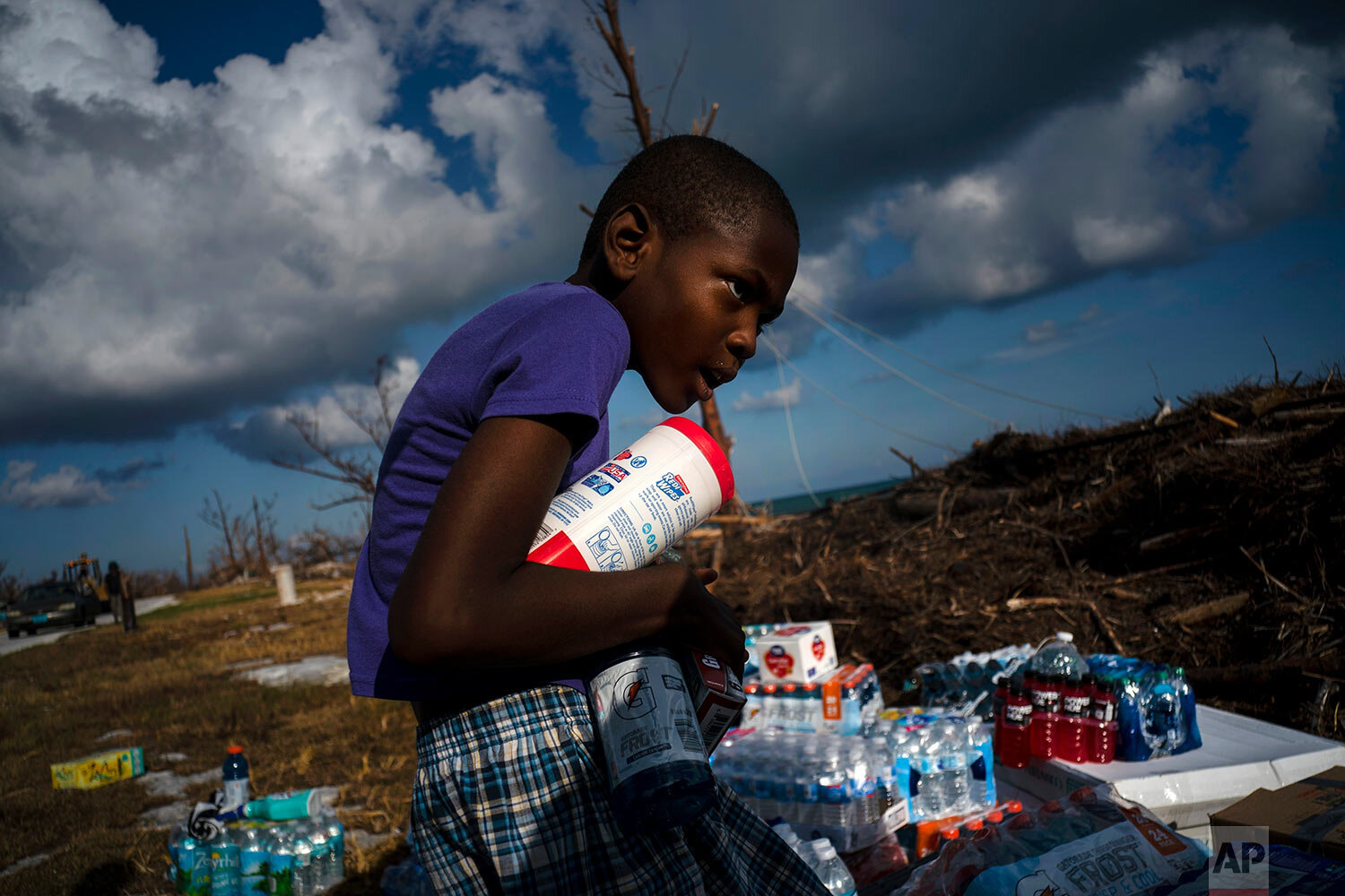  Ayfon Minus, 8, collects donated food that was brought by helicopter from Freeport to the Hurricane Dorian destroyed village of High Rock, Grand Bahama, Bahamas, Tuesday, September 10, 2019. (AP Photo/Ramon Espinosa) 