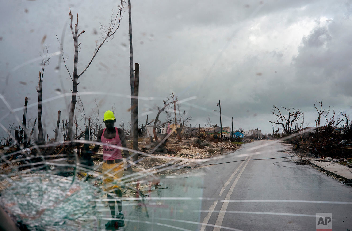 Trees destroyed by Hurricane Dorian line a road as a man walks by, in Abaco, Bahamas, Monday, Sept. 16, 2019. (AP Photo/Ramon Espinosa)
