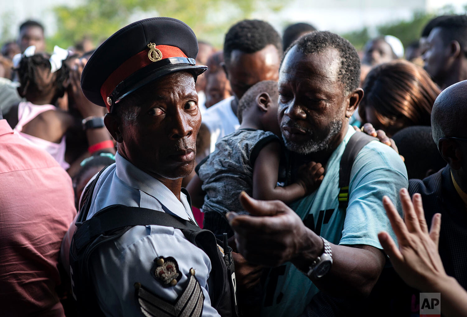  Haitian immigrants displaced from the island of Abaco because of Hurricane Dorian wait to get food from humanitarian organizations in Nassau, Bahamas, Sunday, Sept. 29, 2019.  (AP Photo / Ramon Espinosa) 