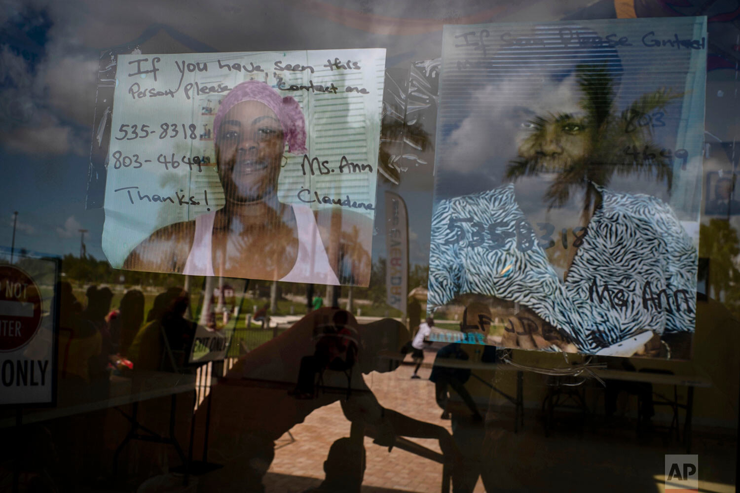 Photos of two women missing during Hurricane Dorian hang from the door of the shelter for displaced people from Abaco because of the destruction by Hurricane Dorian in Nassau, Bahamas, Saturday, Sept. 28, 2019. (AP Photo / Ramon Espinosa)