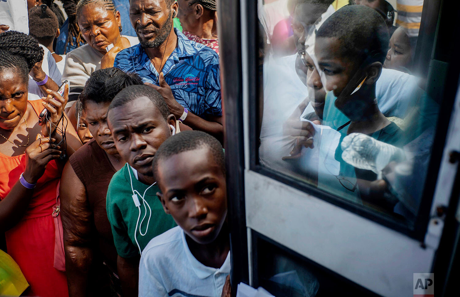 Haitian migrants displaced from their homes destroyed by Hurricane Dorian at Abaco Island wait to get on a bus to receive aid from humanitarian organizations, in Nassau, Bahamas, Sunday, Sept. 29, 2019. A preliminary report estimates Dorian caused some $7 billion in damage, but the government has not yet offered any figures. (AP Photo/Ramon Espinosa)