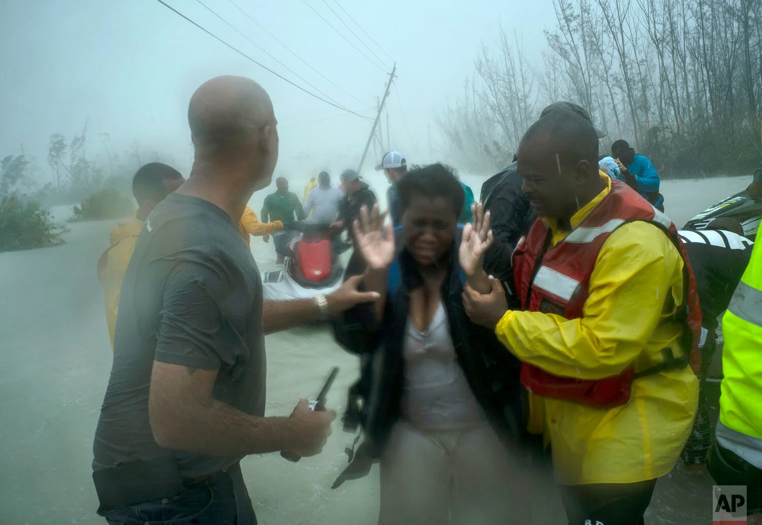 Volunteers rescue several families that arrived on small boats, from the rising waters of Hurricane Dorian, near the Causarina bridge in Freeport, Grand Bahama, Bahamas, Tuesday, Sept. 3, 2019. (AP Photo/Ramon Espinosa)
