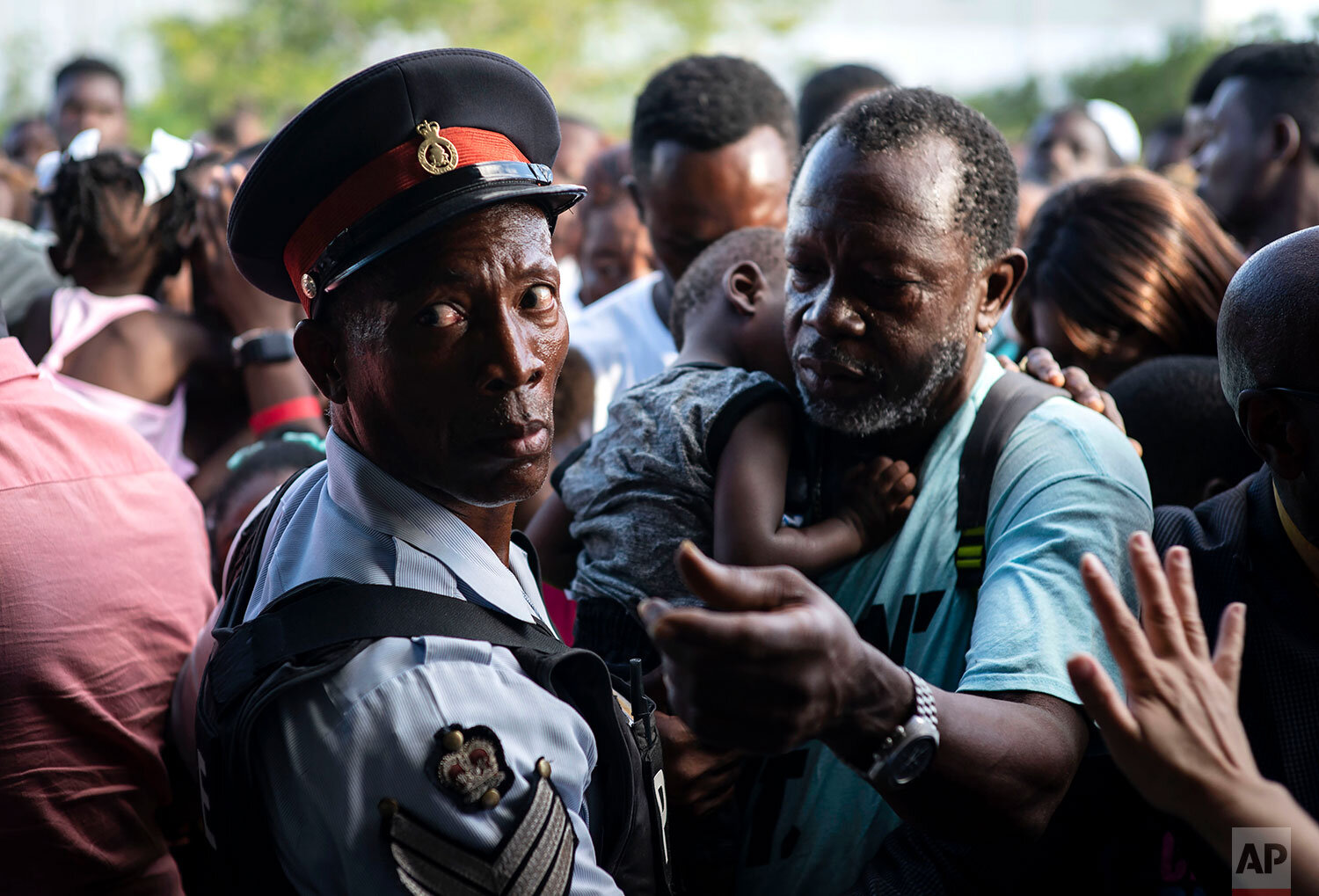 Haitian immigrants displaced from the island of Abaco because of Hurricane Dorian wait to get food from humanitarian organizations in Nassau, Bahamas, Sunday, Sept. 29, 2019. (AP Photo / Ramon Espinosa)
