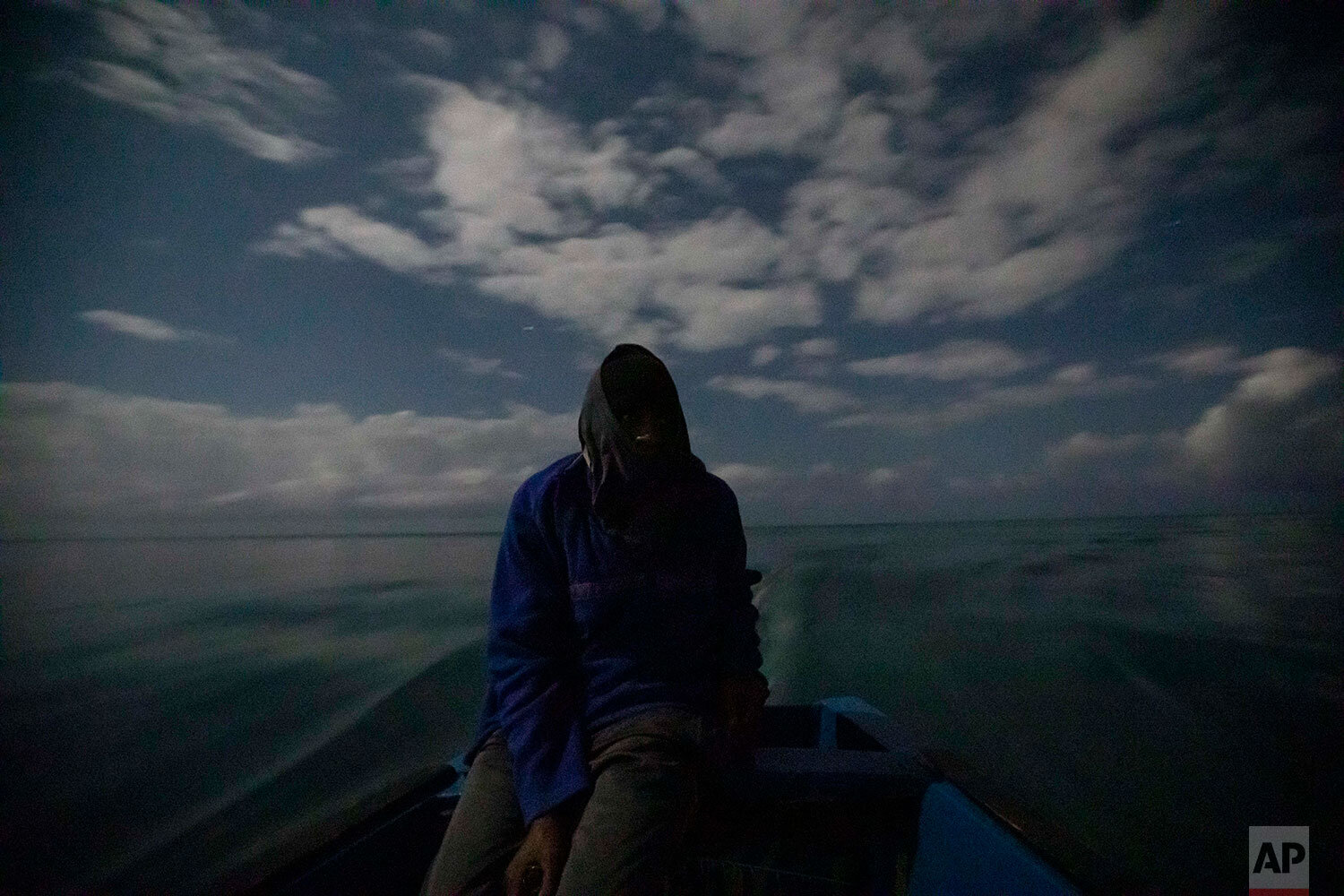 White River Fish Sanctuary warden Mark Lobban steers the boat under moonlight while patrolling the no-take zone for illegal fishermen in Ocho Rios, Jamaica, Friday, Feb. 15, 2019. Two years ago, fishermen joined with local businesses to form a marin