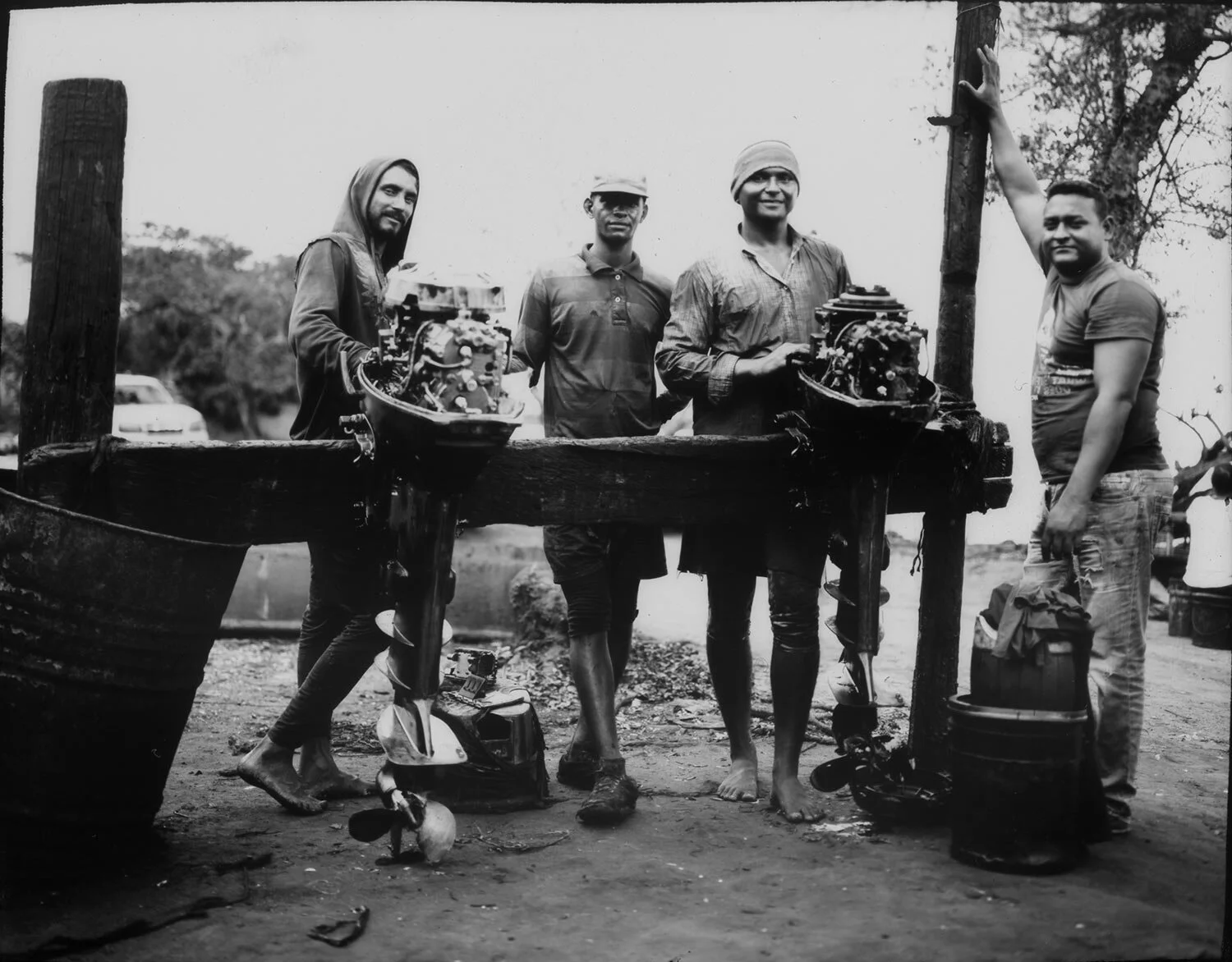 In this July 3, 2019 photo, the owner of the fishing boats, Giovani Blanco, right, poses for a picture with his assistants while repairing the engines damaged due to oil caused by the neglected and lack of maintenance of the state owned PDVSA in and around Lake Maracaibo, Cabimas, Venezuela. (AP Photo/Rodrigo Abd)