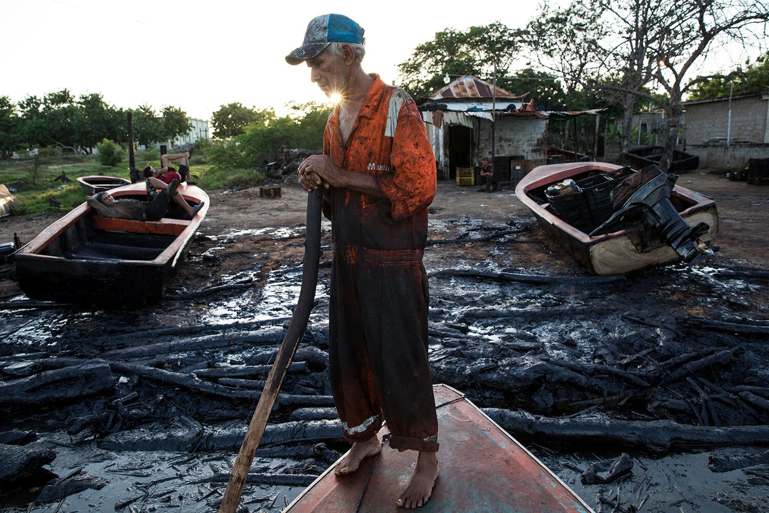 Fisherman William Vilchez arrives to the oil-covered shoreline of Lake Maracaibo in Cabimas, Venezuela, May 18, 2019. (AP Photo/Rodrigo Abd)