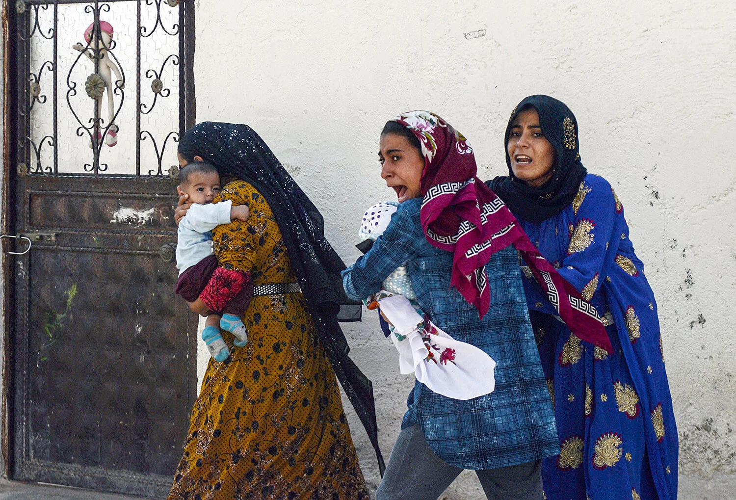 People run to take cover after mortars fired from Syria hit Akcakale, Turkey, on Thursday, Oct. 10, 2019. On Friday, Turkish forces faced fierce resistance from U.S.-allied Syrian Kurdish fighters on the third day of Ankara's offensive in northern Syria, as casualties mounted, international criticism of the campaign intensified and estimates put the number of those who fled the violence at 100,000. (Ismail Coskun/IHA via AP )