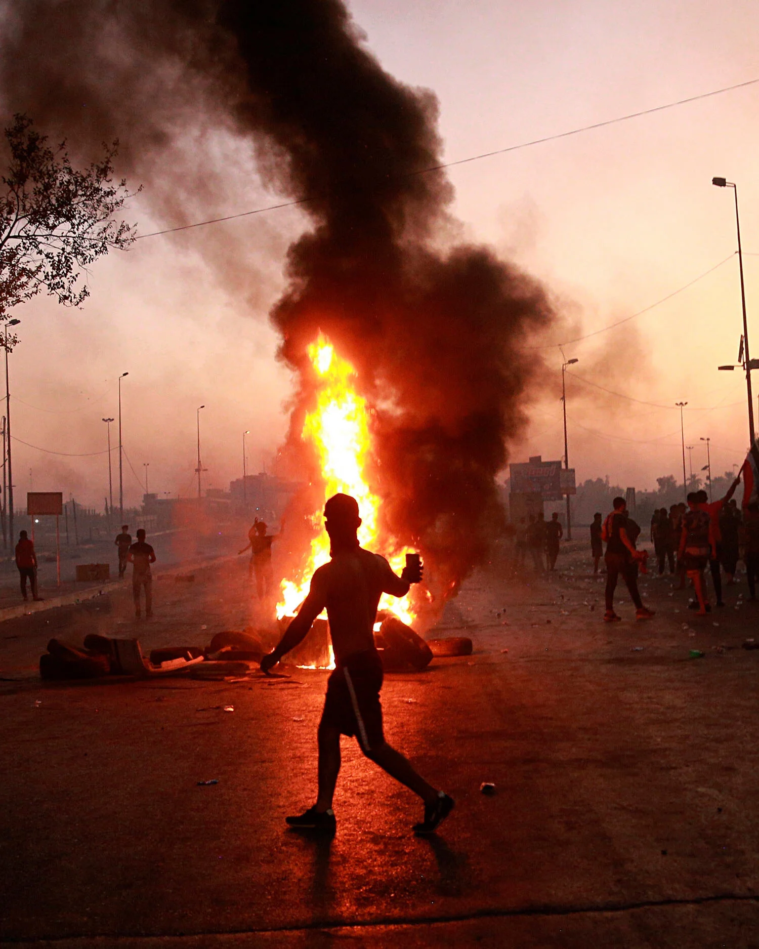 Anti-government protesters set fires and close a street during a demonstration in Baghdad, Iraq, Saturday, Oct. 5, 2019. The spontaneous protests which started Tuesday in Baghdad and southern cities were sparked by endemic corruption and lack of jobs. Security responded with a harsh crackdown, killing dozens. (AP Photo/Hadi Mizban)