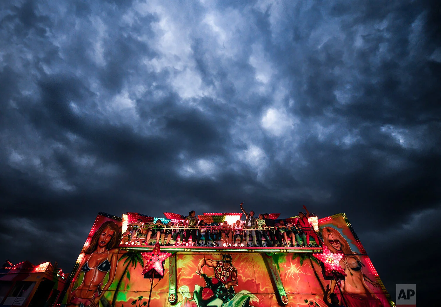 People enjoy a ride at an autumn fair in Titu, southern Romania, Sept. 14, 2019. (AP Photo/Andreea Alexandru)
