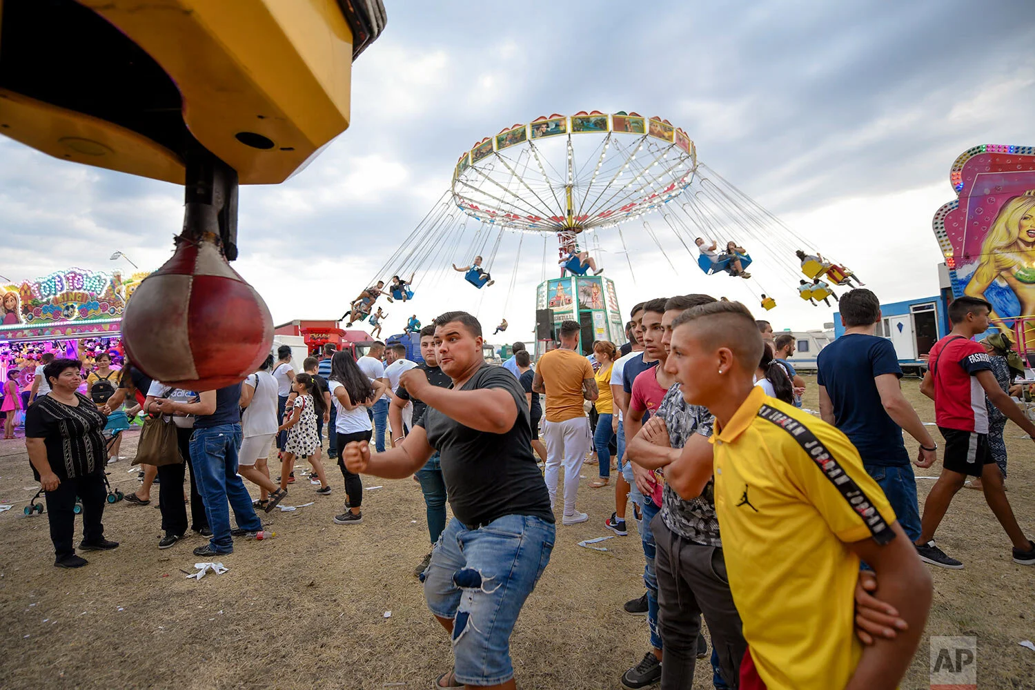 A man tests his strength at a boxing power punch machine at an autumn fair in Titu, southern Romania, Sept. 14, 2019. (AP Photo/Andreea Alexandru)