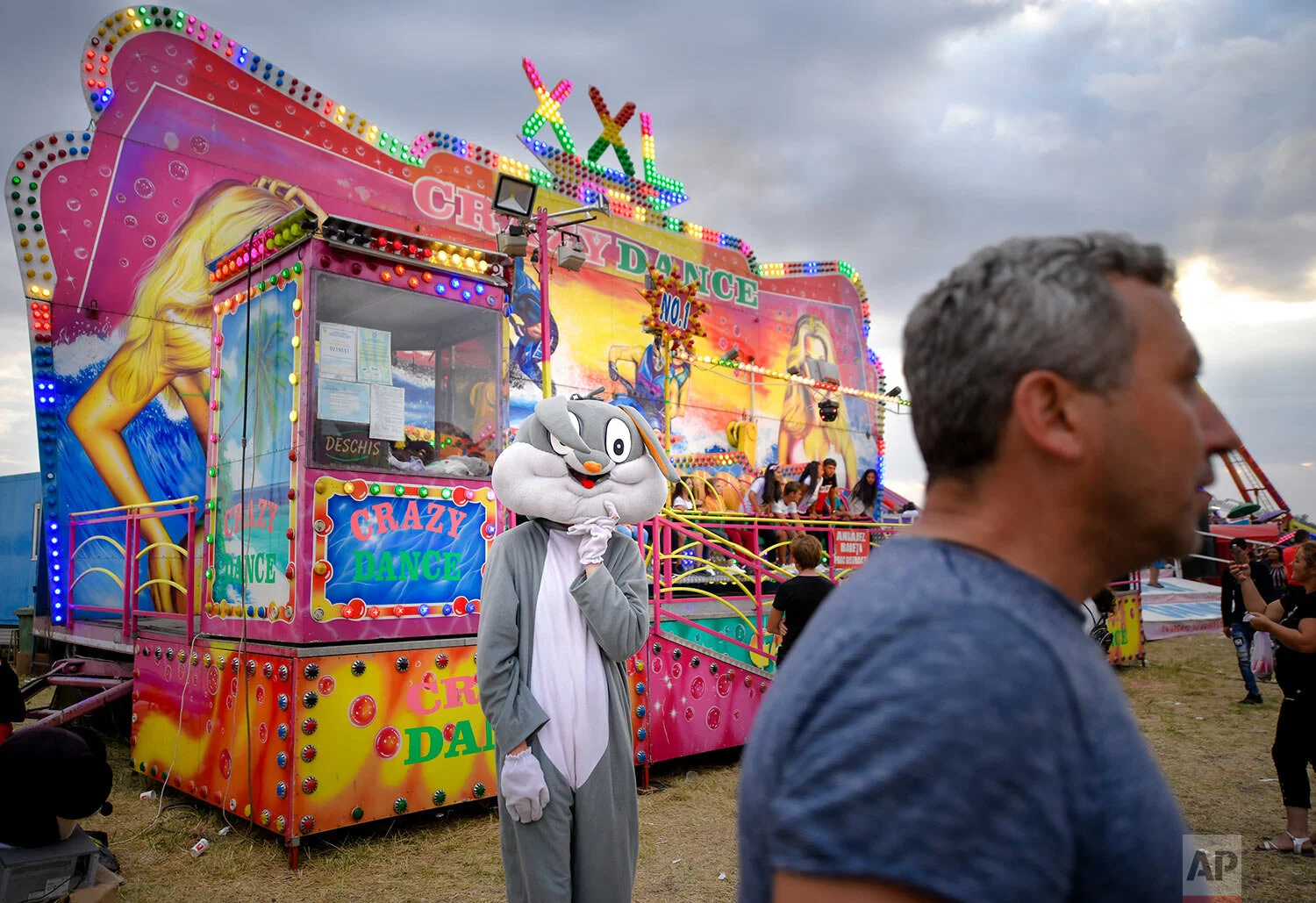 A person wearing a rabbit outfit stands by a ride at an autumn fair in Titu, southern Romania, Sept. 14, 2019. (AP Photo/Andreea Alexandru)