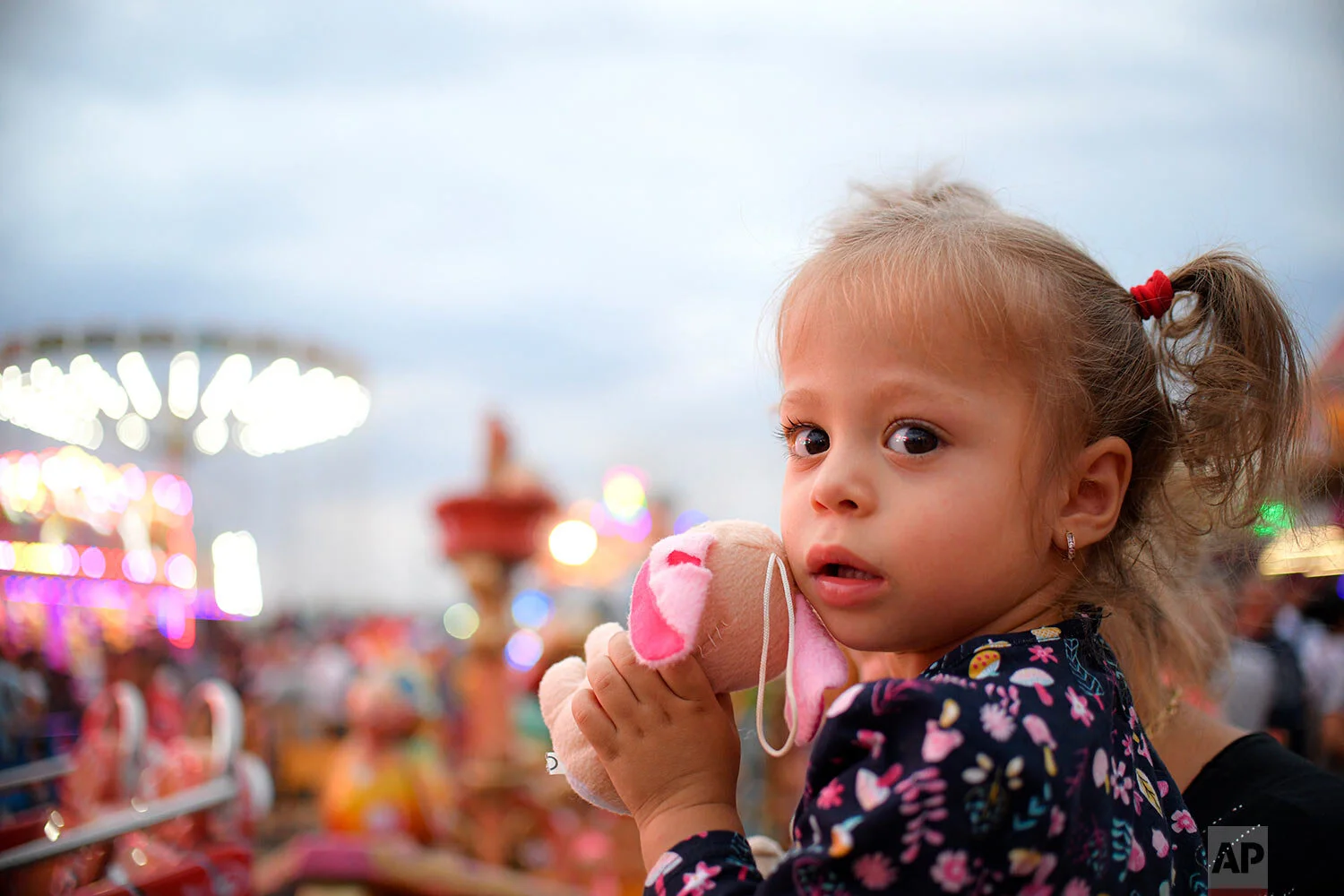 A little girl holds a toy at an autumn fair in Titu, southern Romania, Sept. 14, 2019. (AP Photo/Andreea Alexandru)