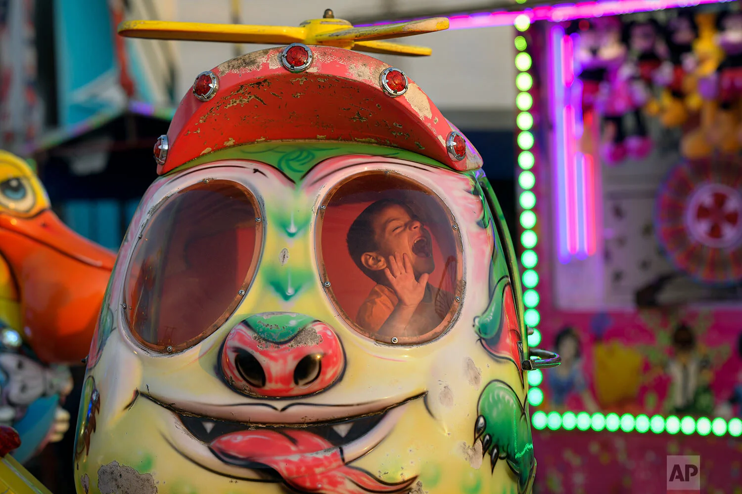 A child laughs while on a ride at an autumn fair in Titu, southern Romania, Sept. 12, 2019. (AP Photo/Andreea Alexandru)