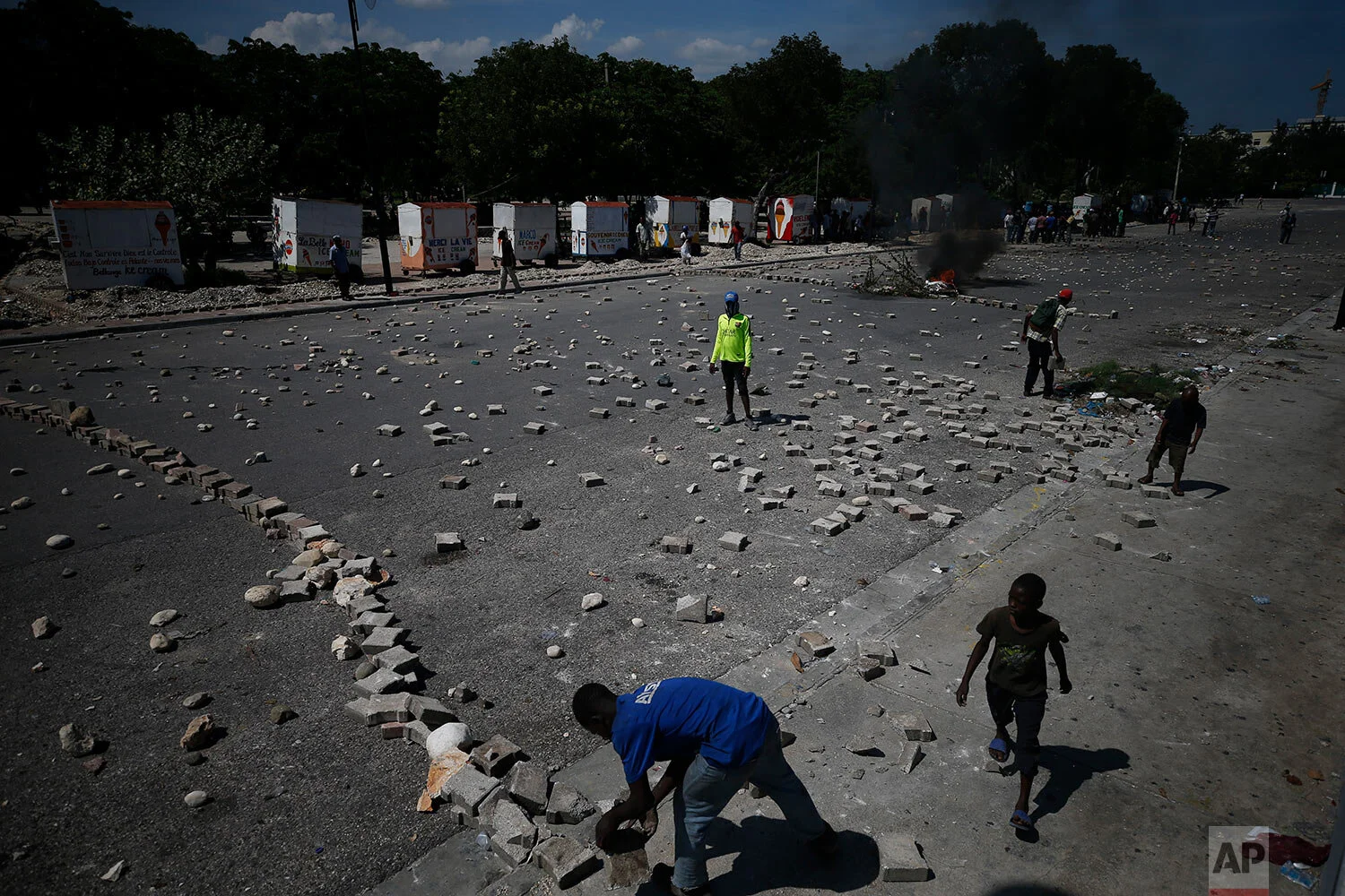 Protesters use paving stones and rocks to barricade a road that runs along the periphery of a park next to the presidential palace in Port-au-Prince, Haiti, Monday, Oct. 7, 2019. (AP Photo/Rebecca Blackwell)