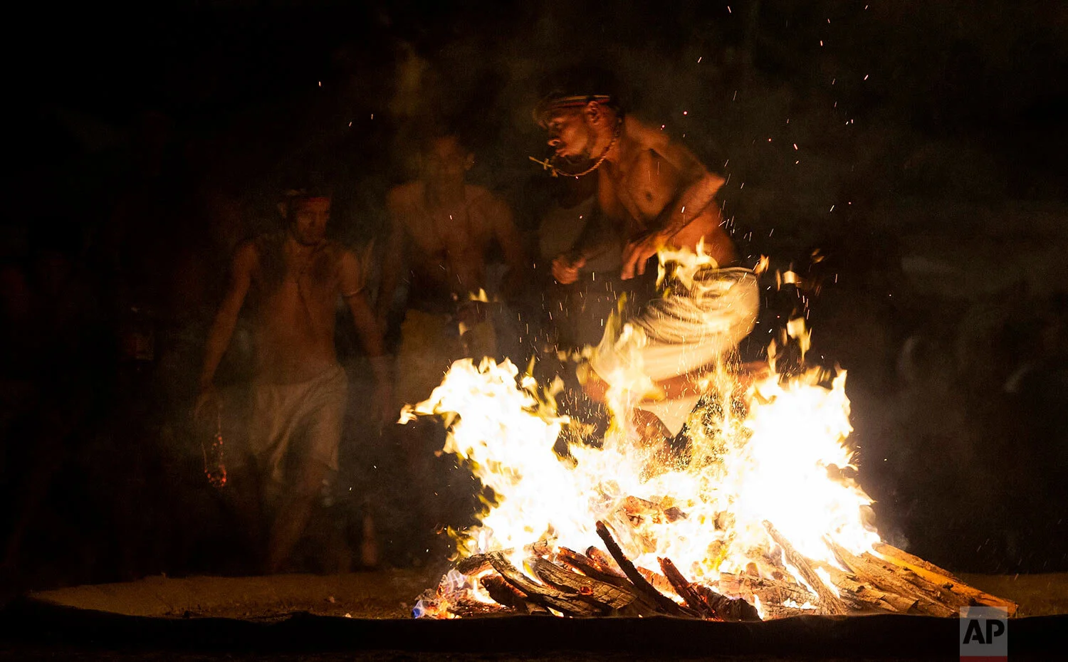 In this photo taken Oct. 11, 2019, a man performs the flame dance on Sorte Mountain where followers of indigenous goddess Maria Lionza gather annually in Venezuela's Yaracuy state. (AP Photo/Ariana Cubillos)