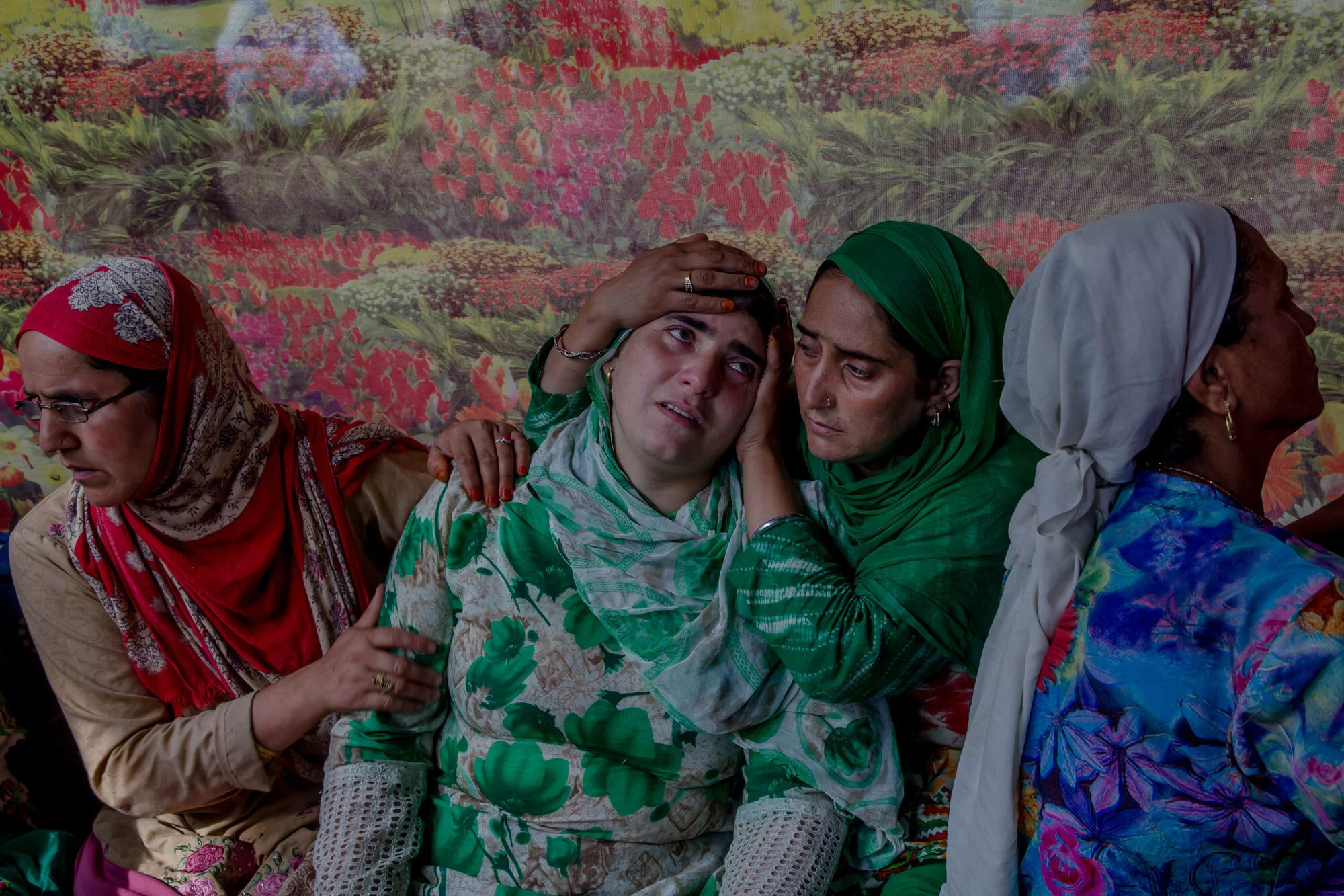 Unidentified relatives comfort the wailing sister of a Kashmiri civilian who was killed during protest near the site of gun battle at her residence in Begumbagh, about 32 kilometers (20miles) south of Srinagar, Indian controlled Kashmir, Aug. 1, 2017. (AP Photo/Dar Yasin)