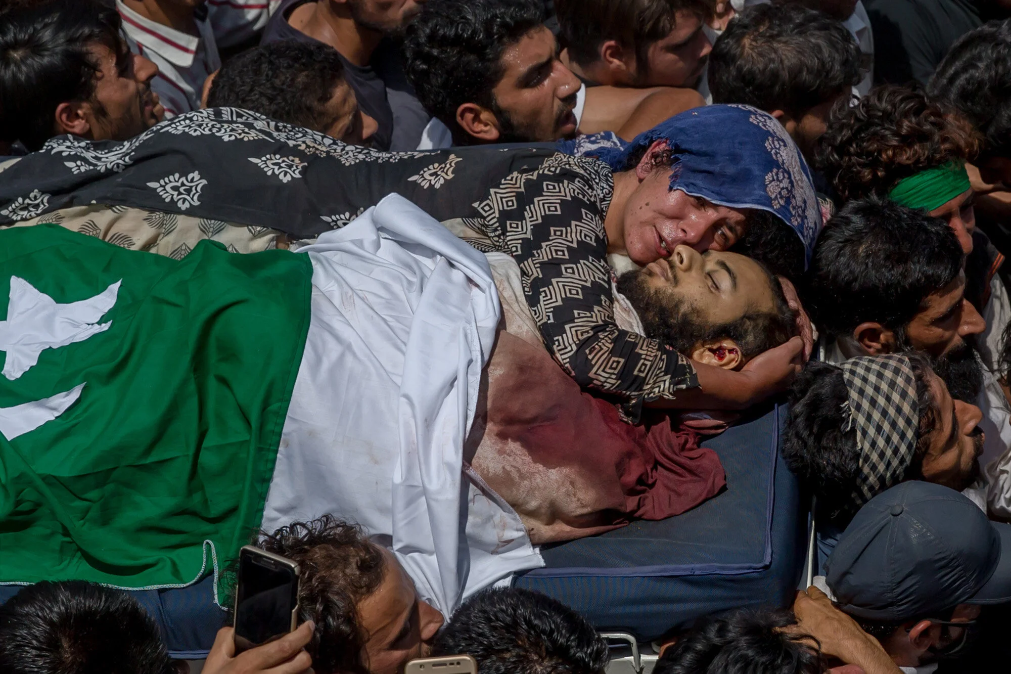 Villagers carry the body of Kashmiri rebel Abid Hamid Mir, as his aunt clings to his body, during his funeral procession in Hajin about 38 Kilometres North of Srinagar, Indian controlled Kashmir, Aug. 5, 2017. (AP Photo/Dar Yasin)
