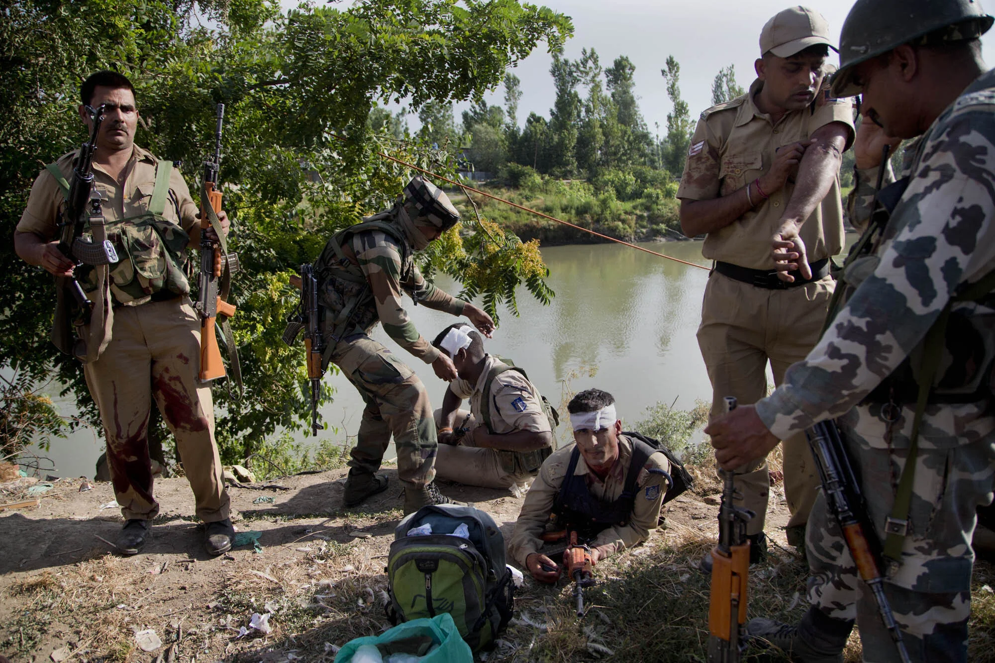 An Indian army soldier, second left, gives first aid to paramilitary soldiers who were injured in a highway ambush in Pampore, on the outskirts of Srinagar, Indian controlled Kashmir, June 25, 2016. (AP Photo/Dar Yasin)