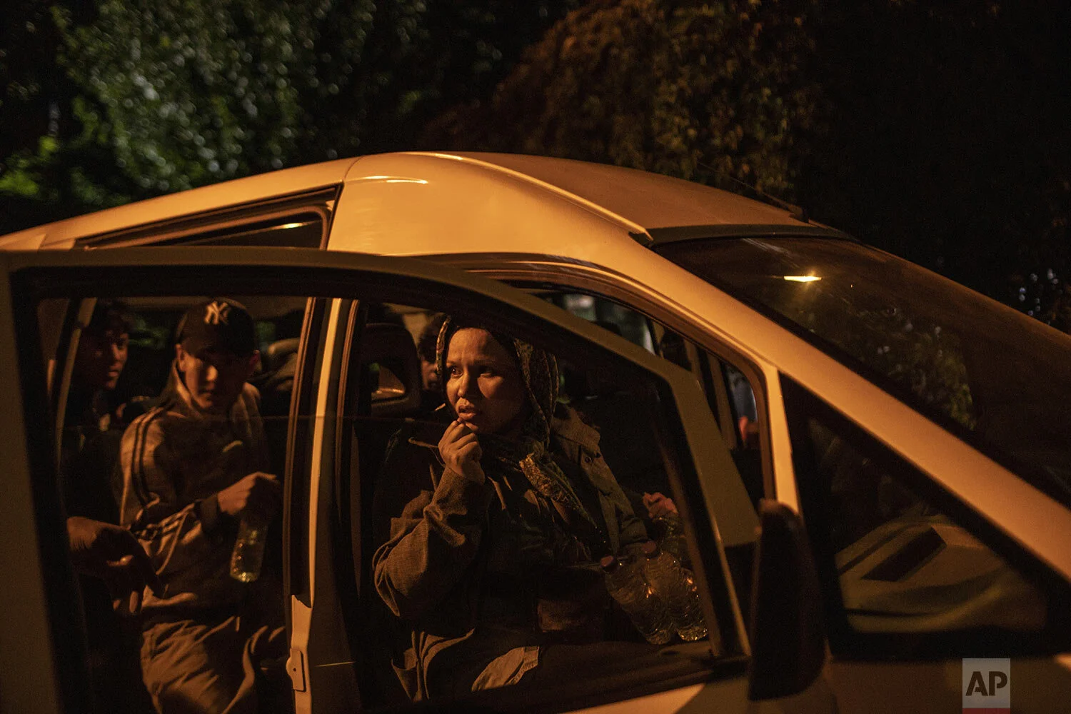 Newly-arrived migrants and refugees look out from a van at the harbor of Skala Sikamias, on the Greek island of Lesbos, early Thursday, Oct. 3, 2019. (AP Photo/Petros Giannakouris)