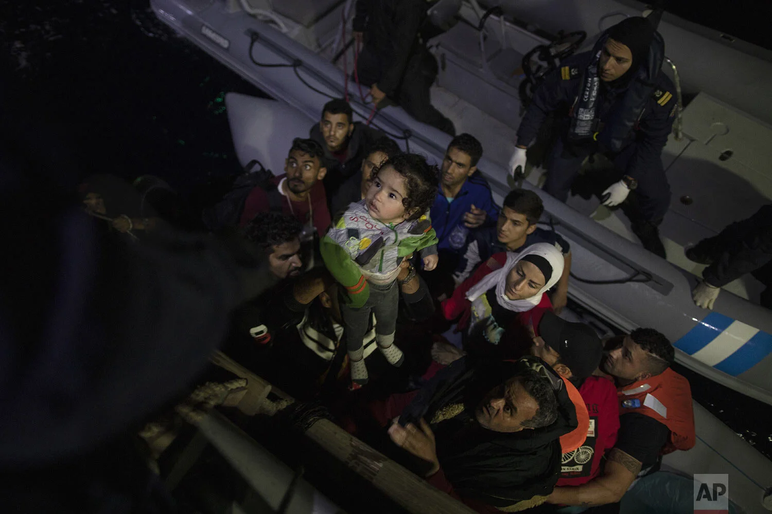 Refugees and migrants are transferred from their dinghy onto a Greek coast guard patrol boat during a rescue operation near the eastern Aegean Sea island of Samos, early Thursday, Sept. 26, 2019. (AP Photo/Petros Giannakouris)