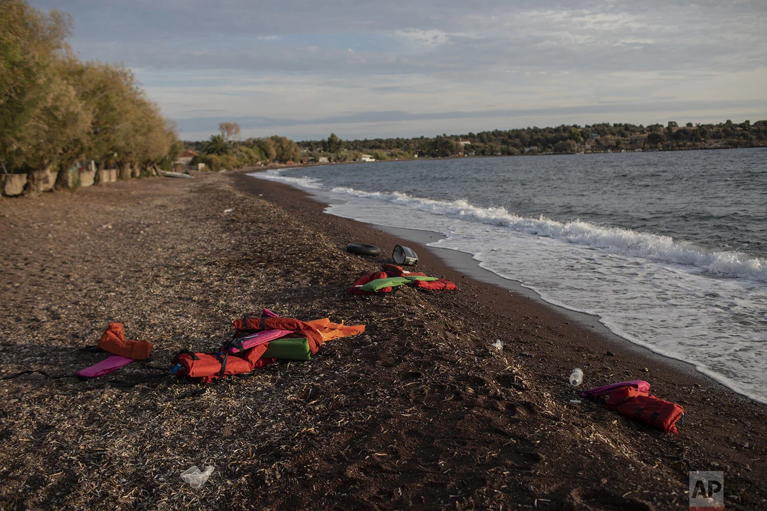 Life vests lay on a beach at the seaside village of Tsonia, Lesbos island, Greece after the arrival of refugees and migrants on a rubber boat from Turkey, Monday, Oct. 7, 2019. (AP Photo/Petros Giannakouris)