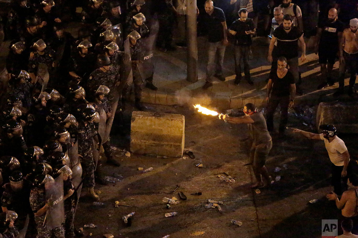 Anti-government protesters clash with riot policemen during a protest against government's plans to impose new taxes in Beirut, Lebanon, Friday, Oct. 18, 2019. Lebanon erupted in protests Thursday over the government's plans to impose new taxes amid a severe economic crisis, taking their anger on politicians they accuse of widespread corruption and decades of mismanagement. (AP Photo/Hassan Ammar)