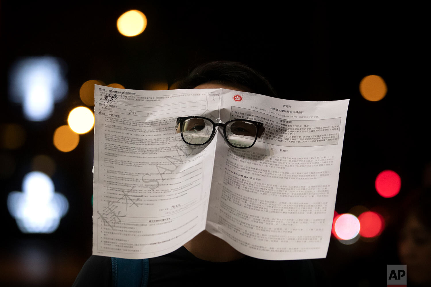  A protester wearing a mask made out of a government form attends a protest in Hong Kong, Friday, Oct. 18, 2019. Hong Kong pro-democracy protesters are donning cartoon and superhero masks as they formed a human chain across the semiautonomous Chinese