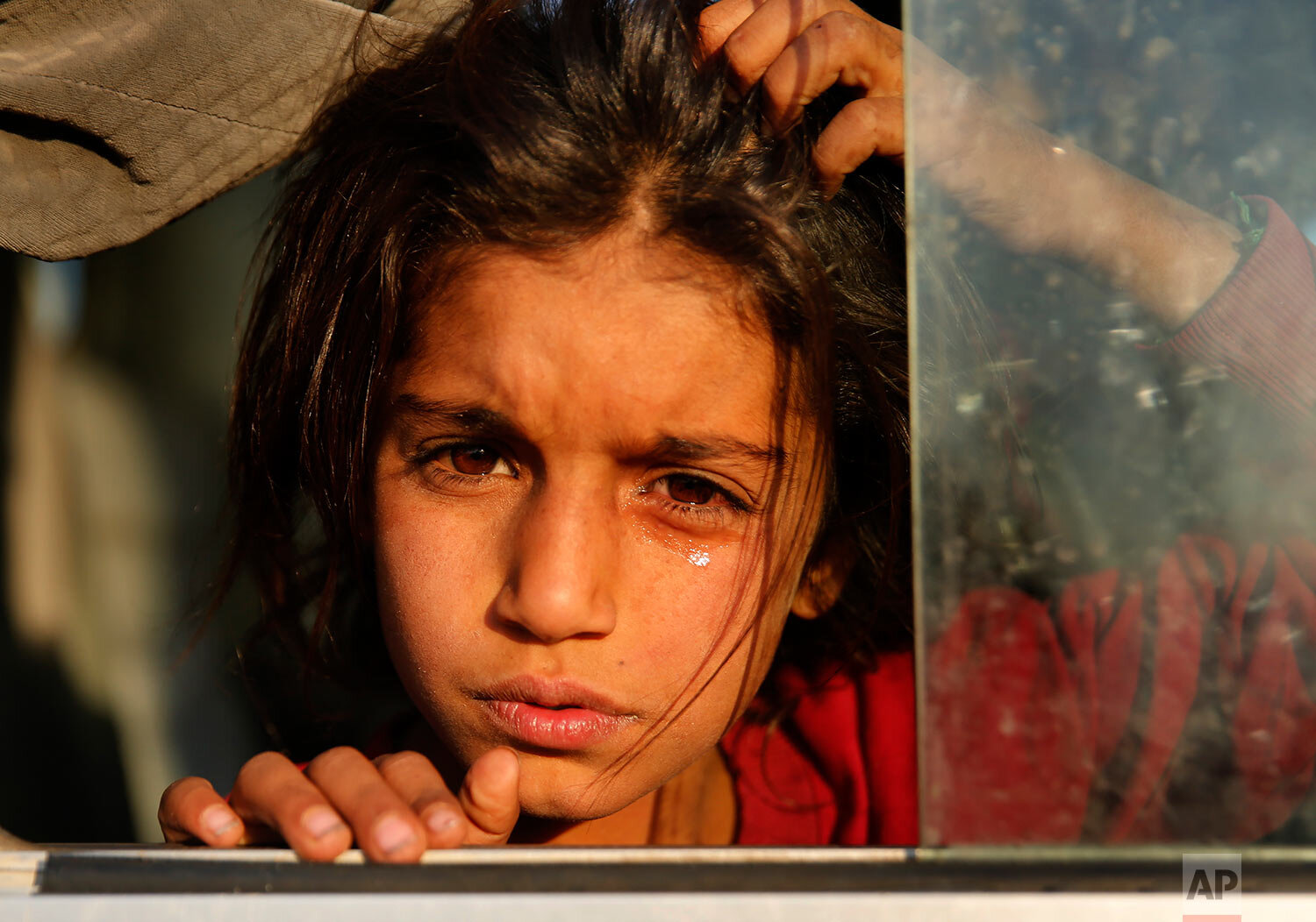  A Syrian girl who is newly displaced by the Turkish military operation in northeastern Syria, weeps as she sits in a bus upon her arrival at the Bardarash camp, north of Mosul, Iraq, Wednesday, Oct. 16, 2019. The camp used to host Iraqis displaced f