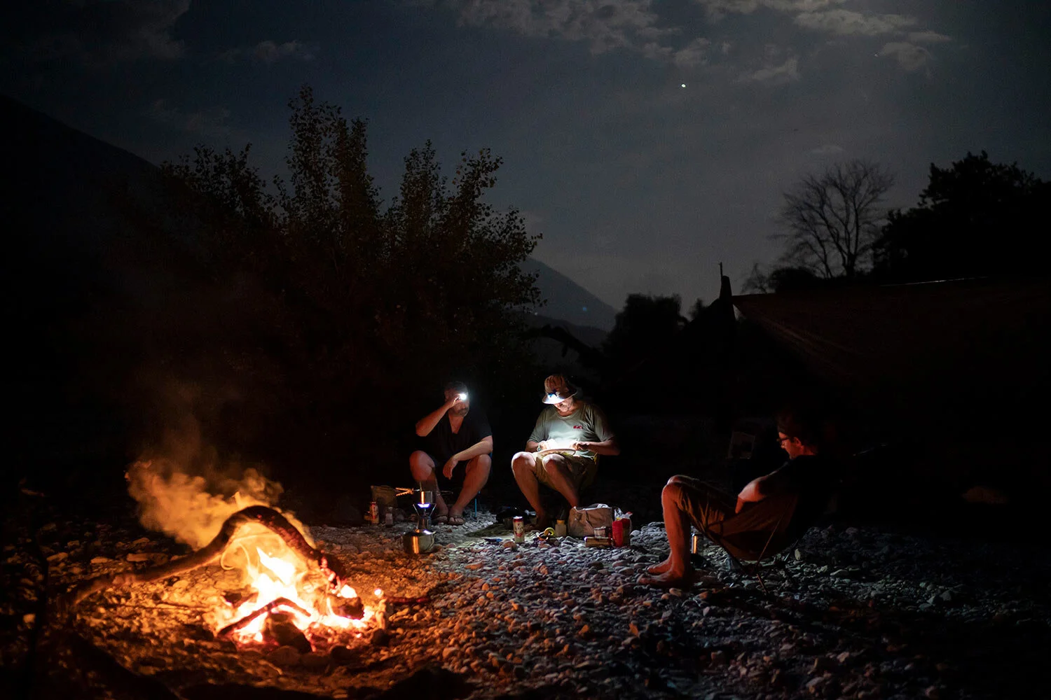Jurgen Steinbauer, Benedikt Baumler and Sebastian Baumler, German tourists who are kayaking the length of the Vjosa River, cook a meal as they sit next to a bonfire on the river bank in Albania. After seeing the Kalivac dam construction site, Benedikt Baeumler said, “It was really unbelievable what they did to nature, removing entire parts of the mountain. I hope this dam is never built.” (AP Photo/Felipe Dana)