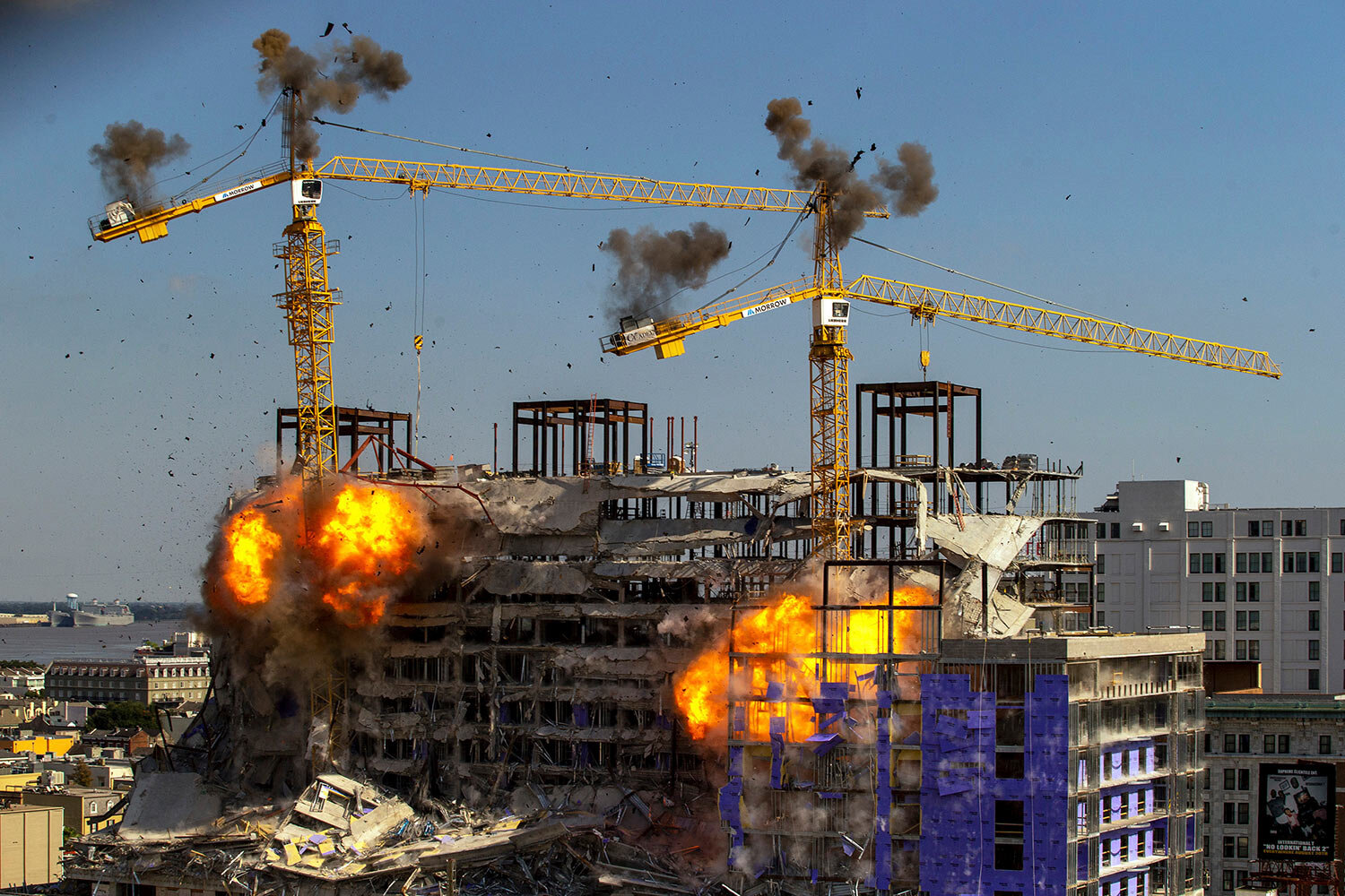 Two large cranes for the partially collapsed Hard Rock Hotel under construction are detonated for implosion in New Orleans, Sunday, Oct. 20, 2019. On Oct. 12, three workers died when several floors of the multistory building pancaked. (David Grunfeld/The Advocate via AP)