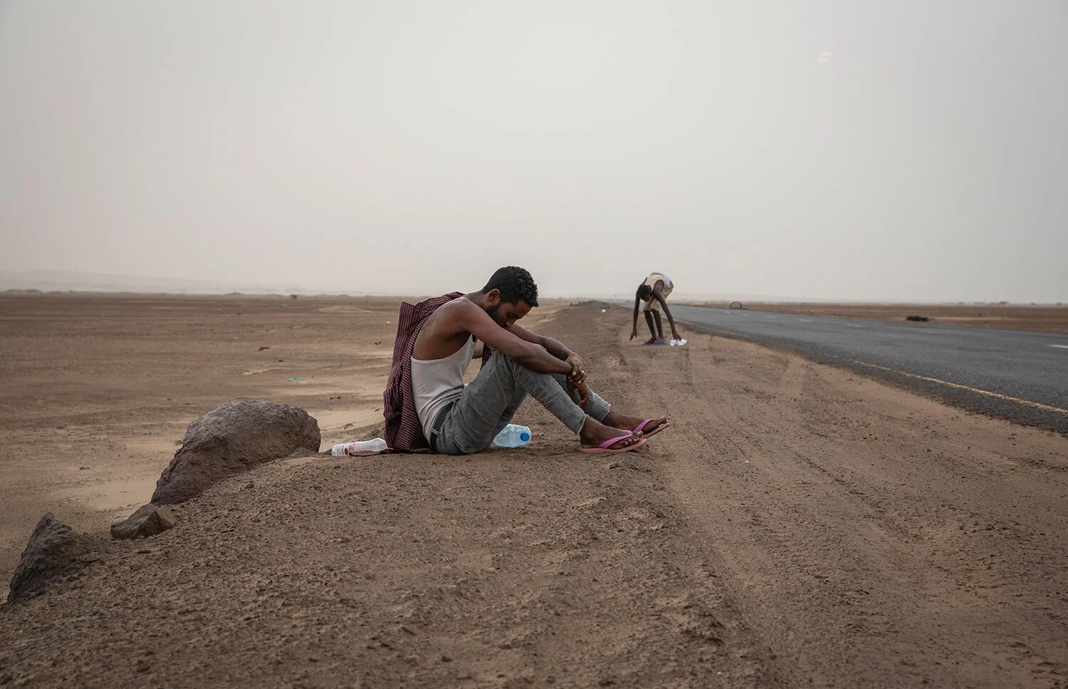 Ethiopian migrants rest on the side of a highway in Lahj, Yemen, early in the morning, as they make their way to Aden. (AP Photo/Nariman El-Mofty)