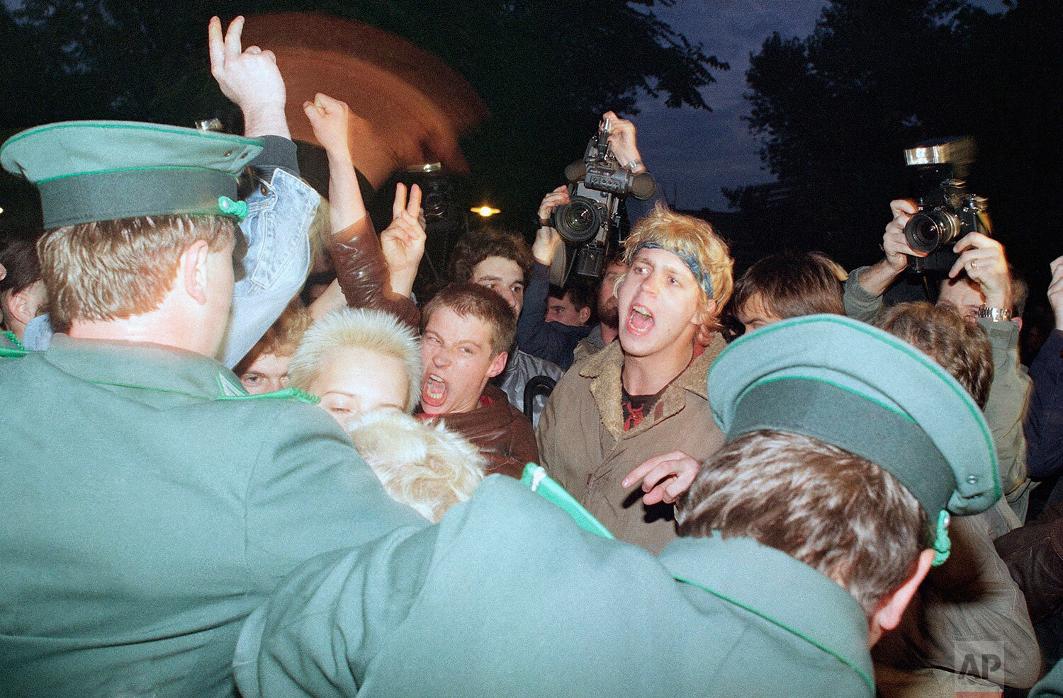  East German policemen, foreground, try to stop demonstrators from moving toward the East German parliament building, Oct. 7, 1989 where Soviet President Mikhail S. Gorbachev attended a reception. (AP Photo/Jockel Finck) 