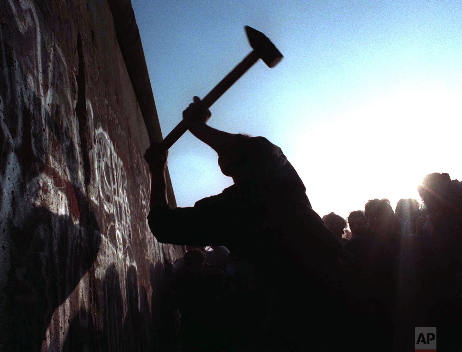  A man hammers away at the Berlin Wall on Nov. 12, 1989 as the border barrier between East and West Germany was torn down after 28 years, symbolically ending the Cold War. (AP Photo/John Gaps III) 