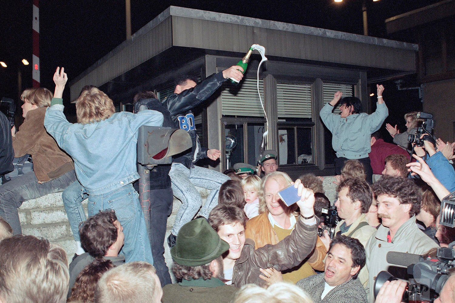  East and West Berliners celebrate in front of a control station on East Berlin territory, Nov. 10, 1989, during the opening of the borders to the West following the announcement by the East German government that the border to the West would be open