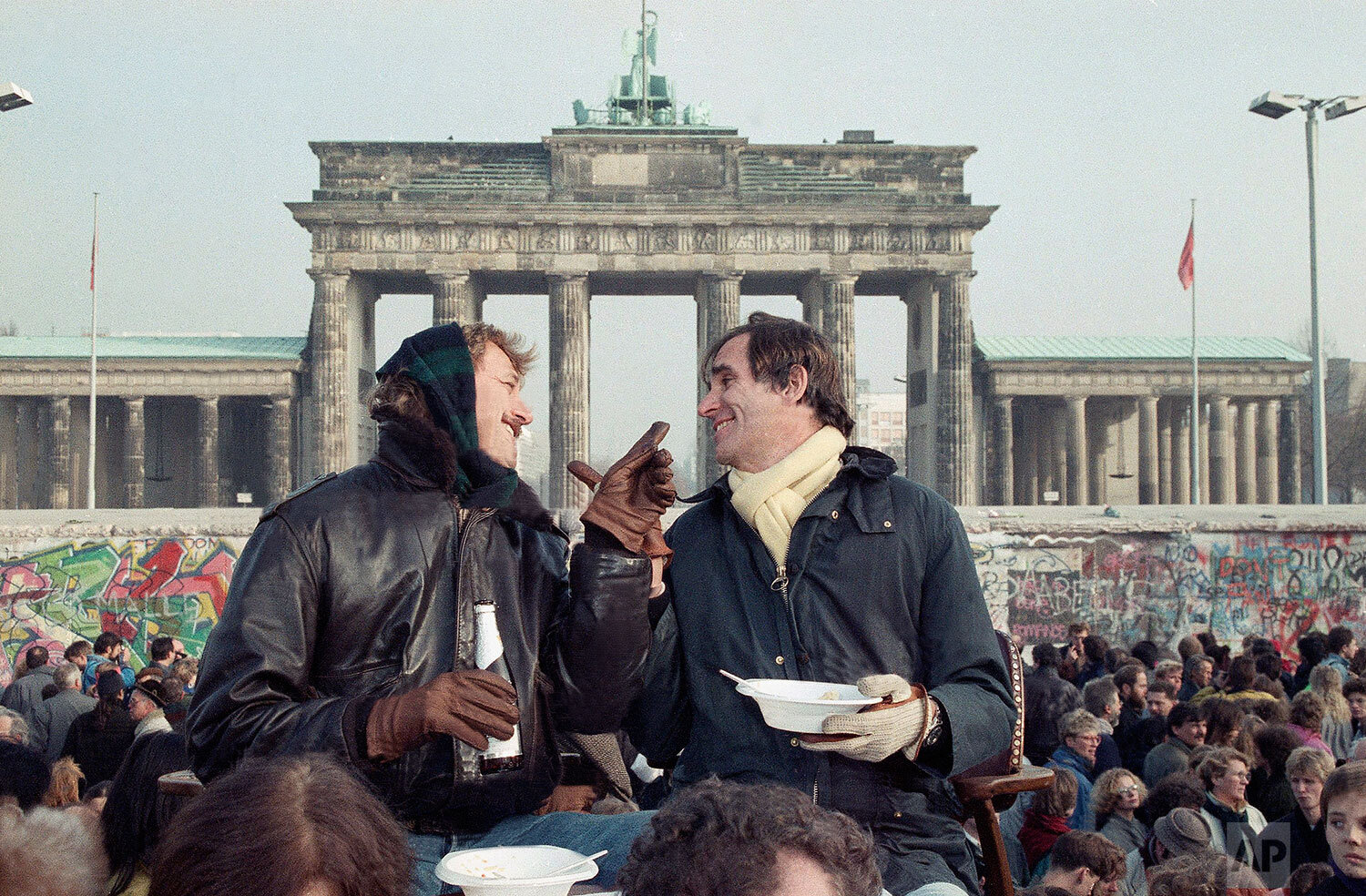  Two Berliners chat in front of Brandenburg Gate in Berlin, Nov. 12, 1989 while having lunch on a visitor's platform near the Berlin Wall. (AP Photo/Lionel Cironneau) 