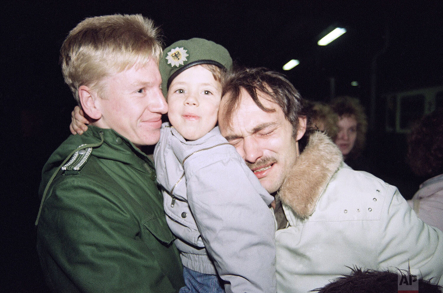  Heinz Joachim Nickel, right, a member of the East German opposition group "New Forum," is overcome with emotion as he and his son, Christian, center, arrive in Helmstedt, West Germany by train from East Germany, Nov. 11, 1989. (AP Photo/Claus Eckert