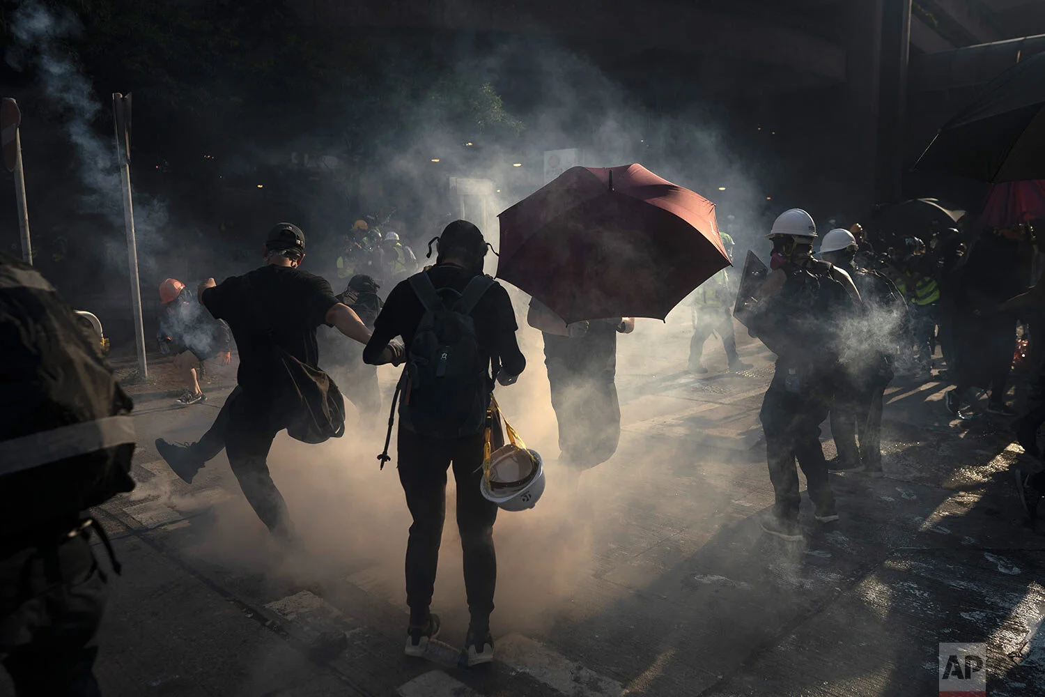 A protestor kicks back an exploded tear gas shell in Hong Kong, Tuesday, Oct. 1, 2019. Hong Kong police shot a protester at close range, leaving him bleeding from his shoulder and howling on the ground, in a fearsome escalation of anti-government demonstrations that spread across the semi-autonomous Chinese territory on Tuesday. (AP Photo/Felipe Dana)