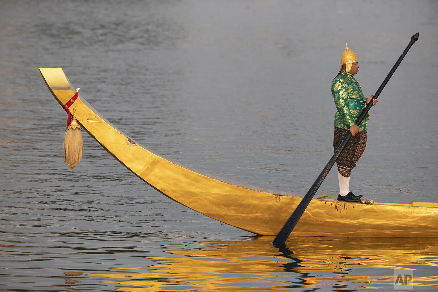 A lone oarsman stands on his boat during the dress rehearsal for the Royal barge ceremony on the Chao Phraya river Bangkok, Thailand, Monday, Oct. 21, 2019. (AP Photo/Sakchai Lalit)
