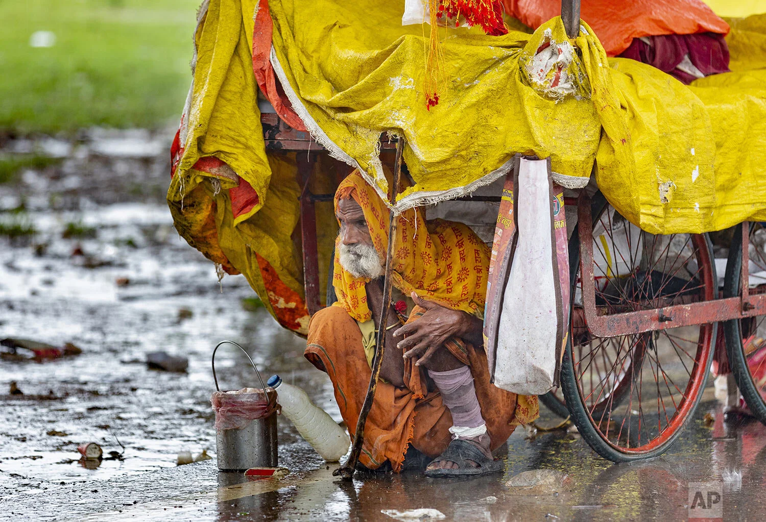 A Sadhu, or Hindu holy man, takes shelter from the rain under a cart in Prayagraj, in the northern Indian state of Uttar Pradesh, Saturday, Sept. 28, 2019. (AP Photo/Rajesh Kumar Singh)