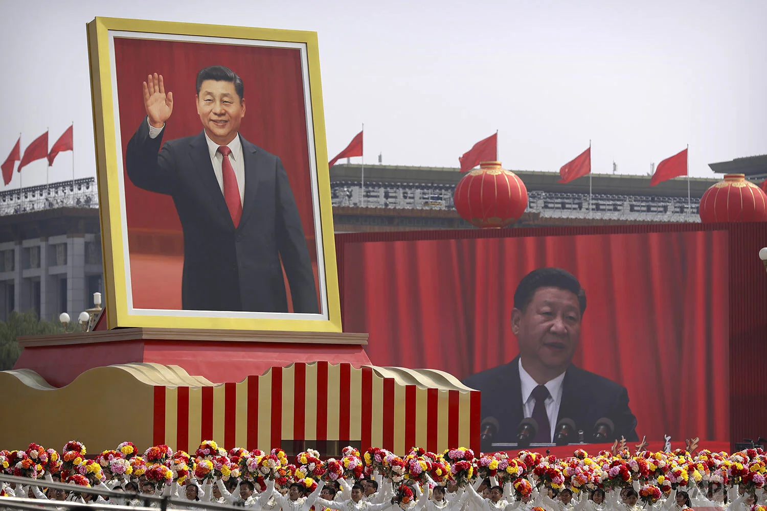 Participants cheer beneath a large portrait of Chinese President Xi Jinping during a parade to commemorate the 70th anniversary of the founding of Communist China in Beijing, Tuesday, Oct. 1, 2019. (AP Photo/Mark Schiefelbein)