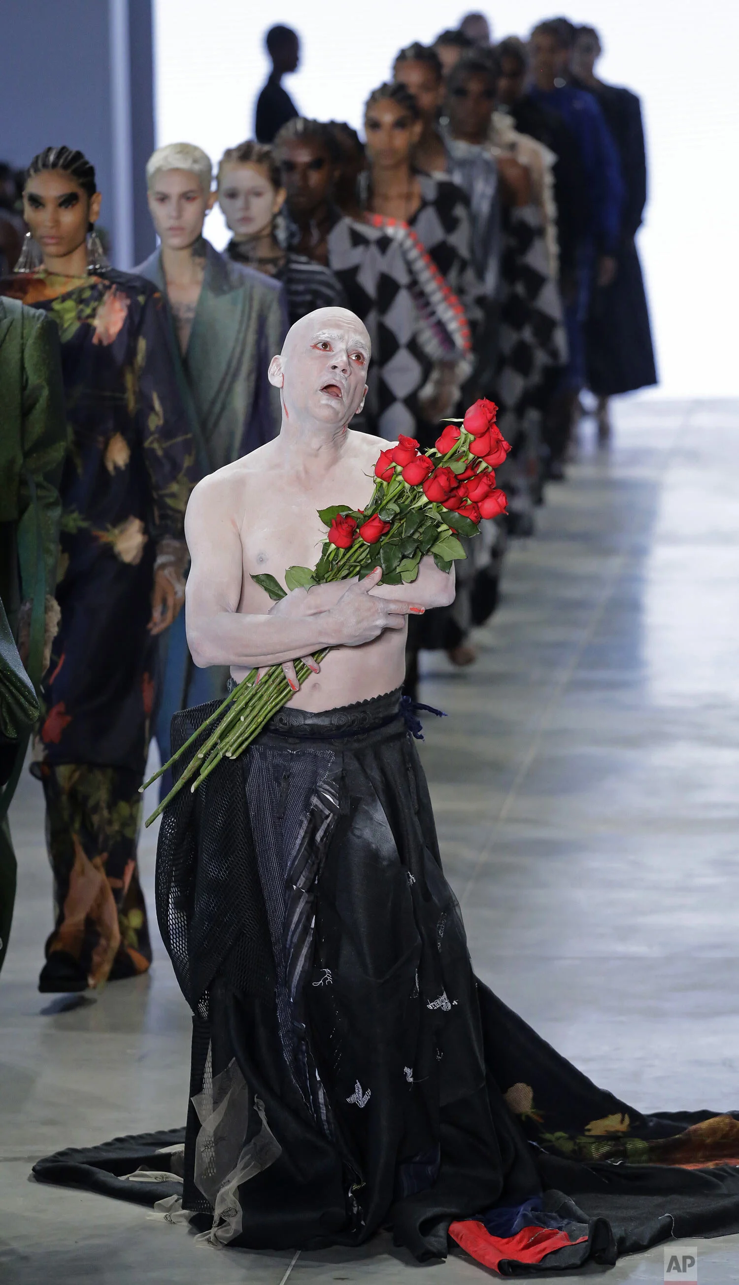 An actor performs while models wear creations from the Apartamento 03 collection during Sao Paulo Fashion Week in Sao Paulo, Brazil, Friday, Oct. 18, 2019. (AP Photo/Nelson Antoine)