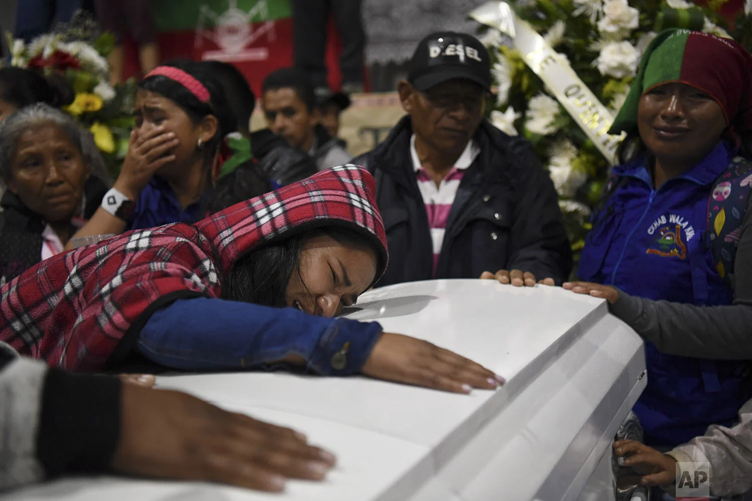 Relatives mourn on the coffin of a slain indigenous leader in Tacueyo, southwest Colombia, Thursday, Oct. 31, 2019. Five people from the Tacueyo reservation were killed late Tuesday when their caravan of armored SUVs was ambushed by gunmen the government says belong to a faction of Revolutionary Armed Forces of Colombia that refused to accept the rebel's group treaty with the government. (AP Photo/Christian EscobarMora)