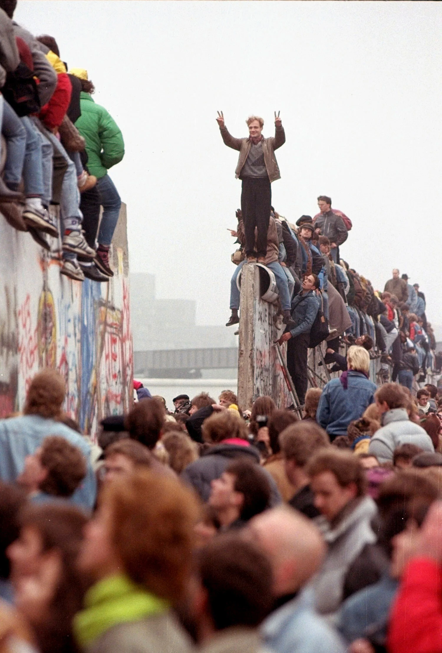 Berliners celebrate on top of the wall as East Germans flood through the dismantled Berlin Wall into West Berlin at Potsdamer Platz, Sunday Nov. 12, 1989, in Berlin. (AP Photo/Lionel Cironneau)