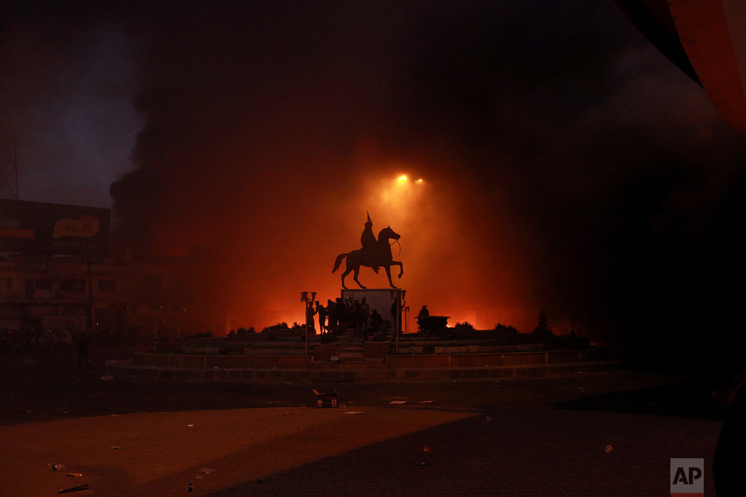  Anti-government protesters set fires while security forces fire live ammunition and tear gas near the state-run television station in Baghdad, Iraq, Monday, Nov. 4, 2019. Demonstrators are complaining of widespread corruption, lack of job opportunities and poor basic services, including regular power cuts, despite Iraq's vast oil reserves. (AP Photo/Hadi Mizban) 