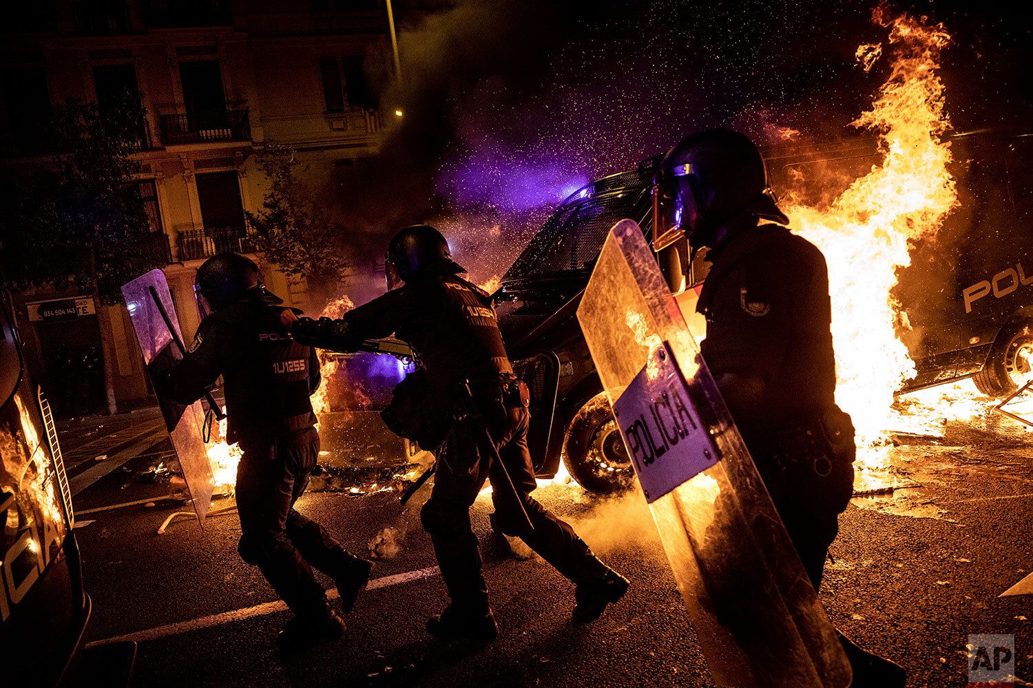  Policemen run as a police van drives over a burning barricade during clashes between protestors and police in Barcelona, Spain, Wednesday, Oct. 16, 2019. Spain's government said Wednesday it would do whatever it takes to stamp out violence in Catalo