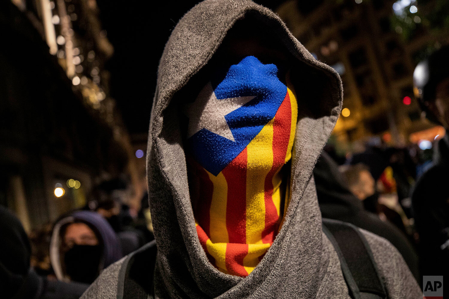  A protester wearing an Estelada or Catalan independence mask stands in front police, not seen, moments before clashes in Barcelona, Saturday, Oct. 26, 2019. The clash comes after 350,000 people protested peacefully Saturday against the imprisonment 