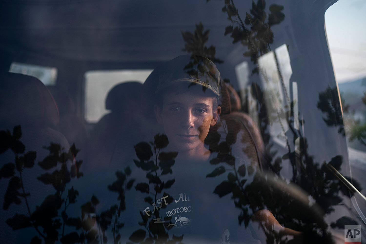  In this June 26, 2019 photo, 13-year-old Eriko, sits in the driver's seat of a car in the village of Kute, Albania. The village overlooks the Vjosa River as it snakes its way north to the sea. Residents here joined a lawsuit against the Pocem dam th