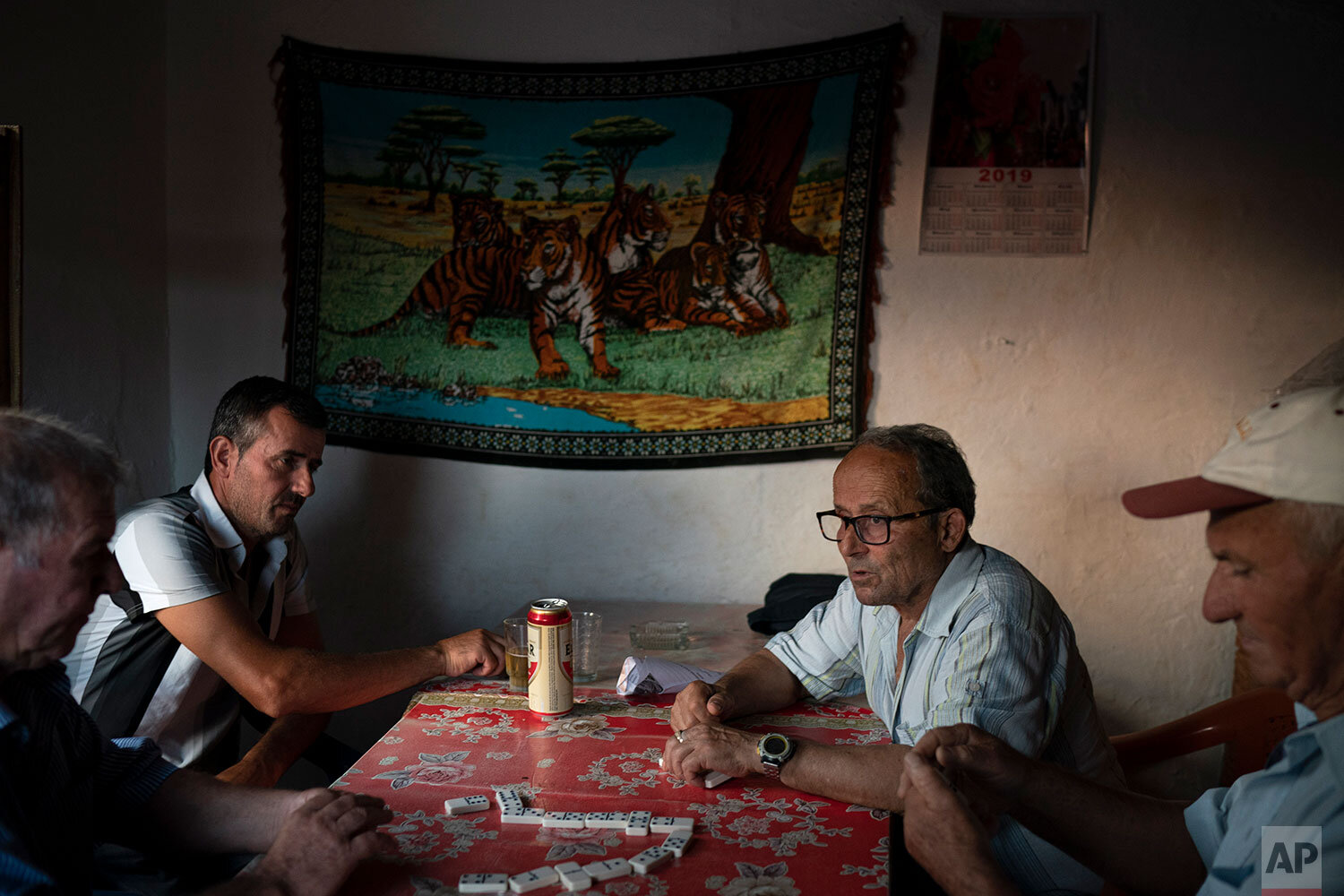  In this June 26, 2019 photo, residents play dominoes in a small bar in the village of Kute, Albania. Dozens of residents from the village joined nonprofit organizations to file what was Albania's first environmental lawsuit against the construction 